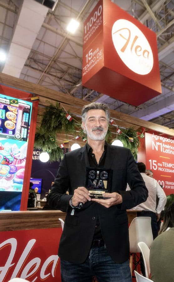Alea's founder, Alexandre Tomic, holding the Award for Best Aggregator Latin America 2024 at SiGMA Americas.